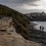 Visiter le cap corse : Nonza, plage rocheuse et randonneurs